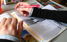 Foto: Schülerin vor aufgeschlagenem Schulbuch
