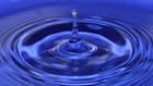 Blauer Wassertropfen in blaues Wasser, zieht Kreise